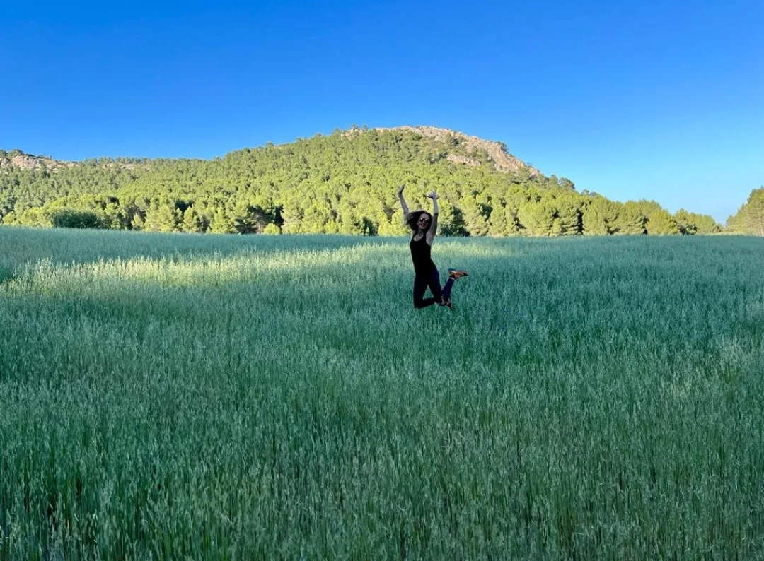 Persona disfrutando de la naturaleza en los campos verdes del Lago del Manzano, conocido como la Suiza murciana